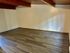 Inviting room with elegant wooden flooring and a charming wood-beamed ceiling, perfect for a cozy retreat.