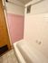 Charming bathroom with retro pink and white tiles featuring a cozy bathtub and elegant wooden door.