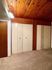 Cozy room with warm wooden ceiling, soft carpet flooring, and ample storage closets.
