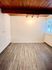 Bright, empty room with stylish wooden ceiling, modern flooring, large windows, and track lighting.