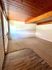 Inviting room with rich wood panel ceiling and cozy carpeted floor, featuring large window for natural light.