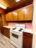 Charming kitchen with vintage wood cabinetry, pink backsplash, and modern white stove offering a cozy cooking space.