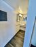 Modern bathroom with sleek lighting and elegant mirror reflecting a spacious interior with stylish flooring.