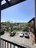 Charming apartment view showcasing a sunny parking lot surrounded by lush greenery and neighboring buildings, perfect for a serene lifestyle.