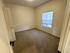 Bright, cozy bedroom with plush carpet and a large window offering natural light.