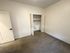 Bright and inviting empty room with plush carpet, fresh white walls, and a spacious closet.