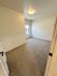 Inviting bedroom with plush carpeting and ample natural light from a large window.