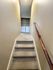 Inviting stairway leading to a modern laundry nook with washer and dryer, offering convenience and style.