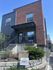 Charming modern apartment building with red brick facade, spacious balcony, and beautifully landscaped entrance at Riverwalk.