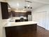 Modern kitchen with elegant dark wood cabinets, stainless steel appliances, and a spacious countertop, ideal for culinary creativity.