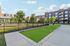 Modern apartment complex featuring lush green spaces, contemporary architecture, and inviting outdoor areas for relaxation.