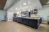 Elegant communal kitchen area featuring modern lighting, sleek countertops, and a cozy seating nook with decorative accents.