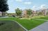 Modern apartment complex with lush green lawns, elegant buildings, and inviting outdoor seating, perfect for relaxation.