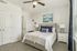 Bright and airy bedroom with modern decor, featuring a plush bed, stylish lamps, and a serene painting, perfect for relaxation.