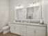 Elegant bathroom showcasing a granite double vanity, large mirror, and soft neutral tones for a serene ambiance.