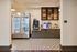 Chic apartment market area with stylish patterned tiles, a sleek stainless steel fridge, and modern coffee station for convenience.