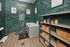 Chic pet wash station with modern green tile walls, luxurious soaking tub, and organized shelving with pet accessories in a stylish apartment complex.