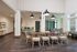 Elegant modern dining area with stylish wooden chairs, vibrant hardwood floors, and ample natural light.