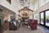 Elegant and spacious common area with high ceilings, modern chandeliers, and stylish seating, perfect for social gatherings.