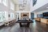 Bright and modern common room with a billiards table, shuffleboard, and stylish seating area adorned with contemporary decor.