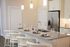 Modern kitchen with elegant granite countertop island, stylish pendant lights, and chic place settings, perfect for entertaining.