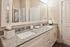 Elegant bathroom featuring a dual sink vanity with sleek granite countertops and modern fixtures, exuding a luxurious and inviting atmosphere.