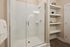 Sleek and modern bathroom with a glass-enclosed shower and elegant built-in shelving, perfect for a stylish home.