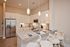 Modern kitchen with sleek granite countertops, stainless steel appliances, and elegant pendant lighting. Features stylish bar seating and crisp white cabinetry for a contemporary feel.