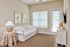 Inviting living room with elegant white sofa, warm natural lighting, and chic bird artwork for a serene atmosphere.