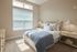 Inviting bedroom filled with natural light, featuring elegant decor, cozy bedding, and charming bedside lamps.