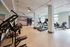 Bright and modern apartment fitness center featuring state-of-the-art exercise equipment, cardio machines, and ample natural light.