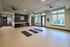 Bright and spacious wellness room with three yoga mats, large windows offering serene garden views, and stylish modern furnishings.