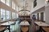 Elegant communal dining area with high ceilings, large windows, and stylish light fixtures, perfect for social gatherings and relaxation.