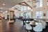 Luxurious communal living area featuring high ceilings, modern chandeliers, a pool table, elegant seating, and large windows.