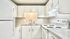Modern apartment kitchen with sleek white cabinets, spacious countertops, and energy-efficient appliances.