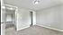 Cozy bedroom with neutral carpeting, closet space and large window.