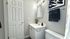 Elegant bathroom with soothing grey walls, stylish vanity, and modern lighting.
