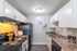 Modern kitchen with sleek appliances, elegant marble countertops, and stylish white cabinetry, ideal for culinary enthusiasts.