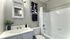 Elegant bathroom featuring a sleek vanity, modern fixtures, and stylish wall art, exuding contemporary charm and comfort.