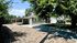 Charming single-story home with shaded driveway, lush trees, and a peaceful neighborhood setting.