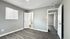 Bright and modern bedroom with sleek hardwood flooring and an en-suite bathroom, creating a serene living space.