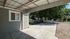 Charming covered patio area overlooking a quaint neighborhood with lush green trees and a tidy driveway.