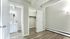 Bright and modern room featuring sleek floors, a spacious closet, and a stylish bathroom vanity, perfect for contemporary living.