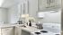 Newly renovated kitchen with white cabinetry and stainless steel sink