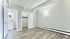 Bright and spacious bedroom with elegant wood-style flooring, walk-in closet, and attached bathroom in modern apartment.