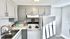 Charming kitchen with modern gray cabinets, spacious countertops, and stainless steel appliances, perfect for cooking enthusiasts.