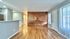 Bright and spacious living area with elegant hardwood floors, stylish wood accent wall.