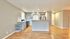 Bright open kitchen with modern cabinetry, sleek stainless steel appliances, and elegant hardwood flooring.