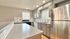 Modern kitchen with sleek stainless steel appliances, ample cabinetry, and natural light from large windows.