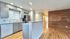 Chic open-plan kitchen with modern gray cabinetry, elegant tile backsplash, and stainless steel appliances.